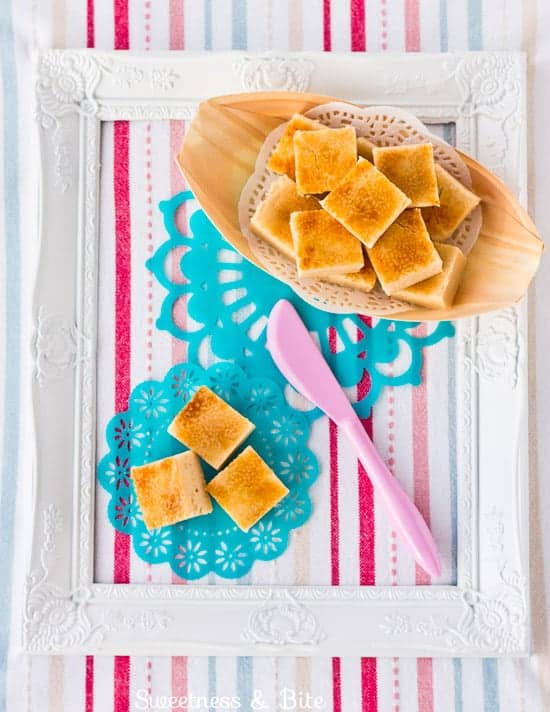 Pieces of creme brûlée fudge on a striped background.