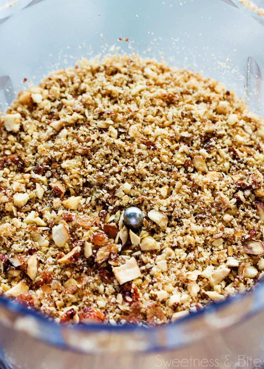 Chopped honey roasted almonds in a small food processor bowl.