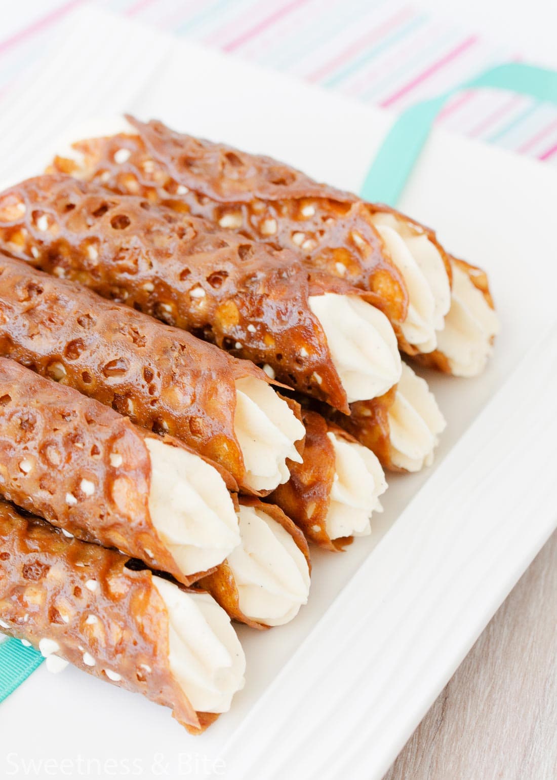 A plate stacked high with cream-filled brandy snaps.