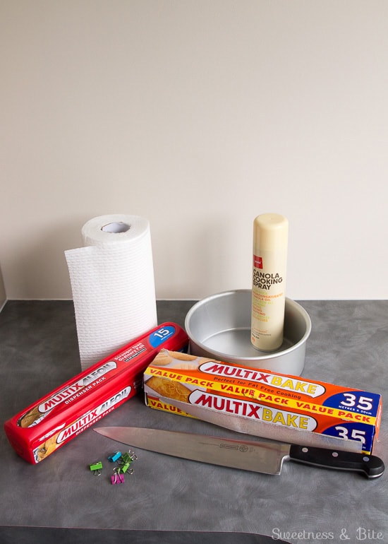The supplies needed to make cake strips - foil, baking paper, cooking oil spray, paper towels, binder clips and a knife.