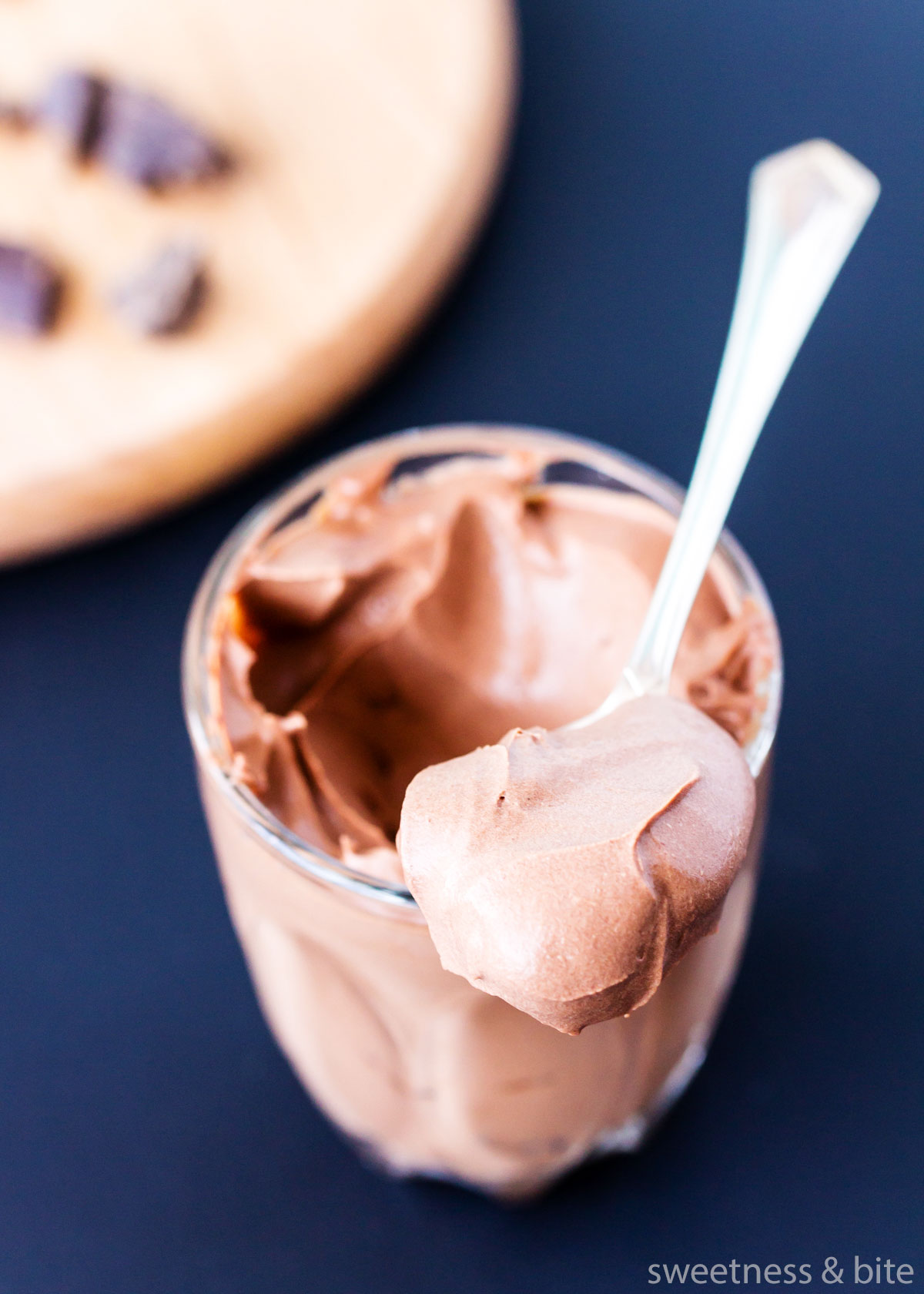 A spoonful of mousse resting on a small glass.