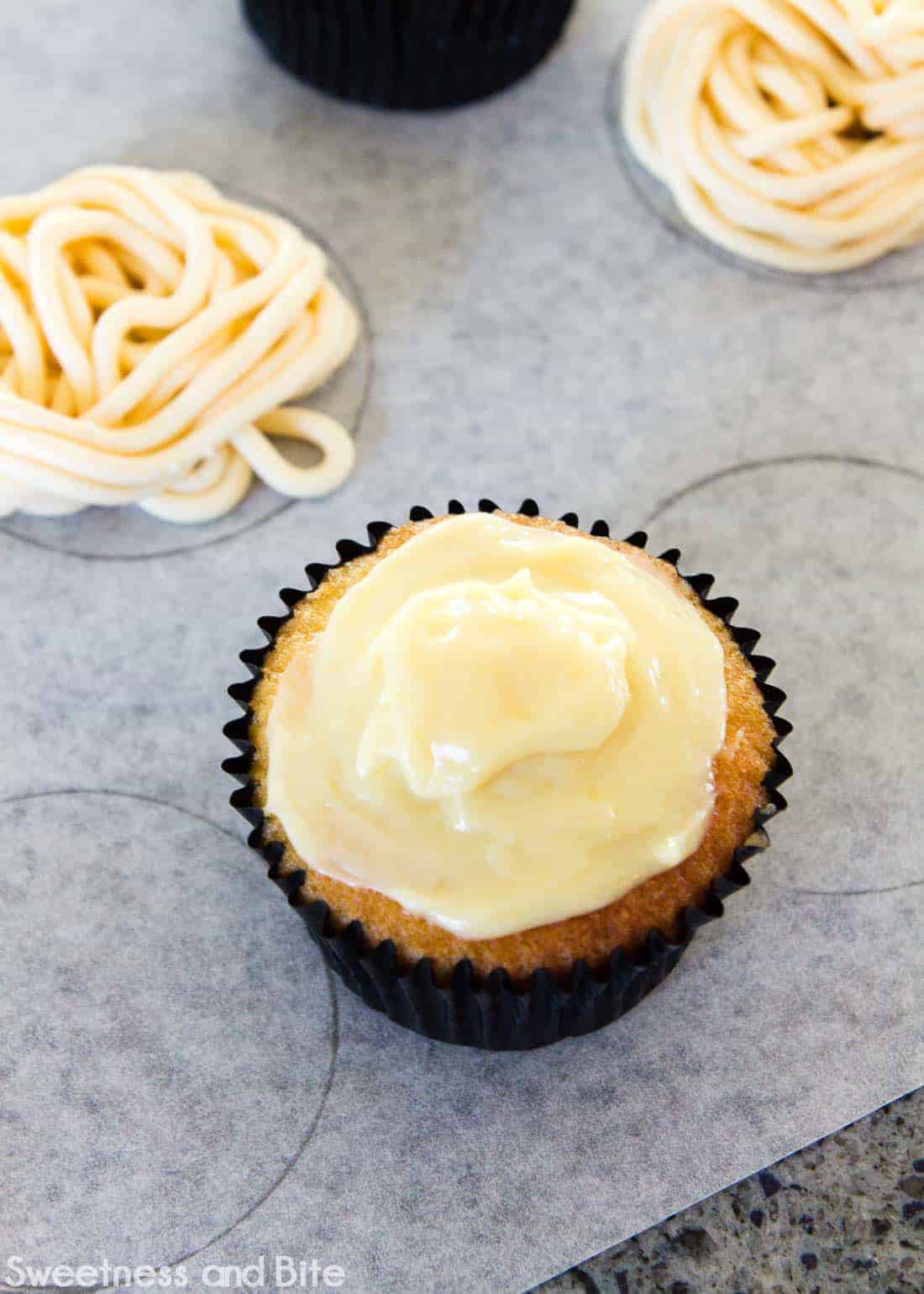 A cupcake spread with white chocolate ganache.