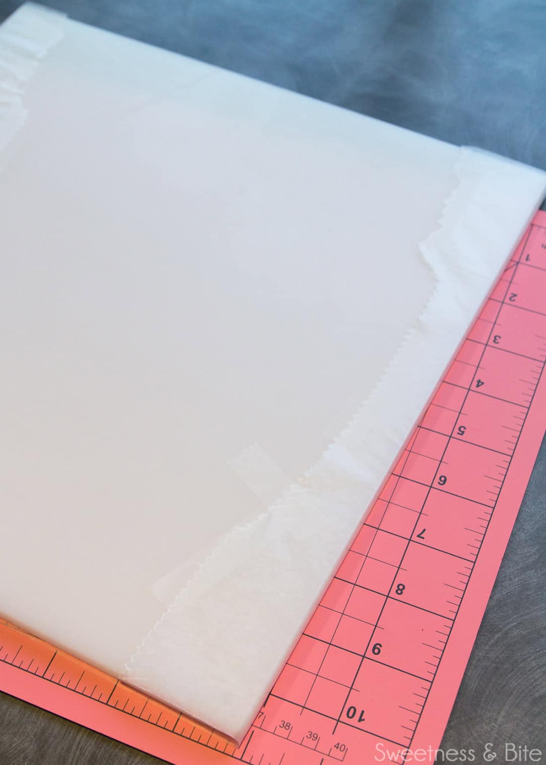 A cake board with waxed paper wrapped around it and taped on the underside.