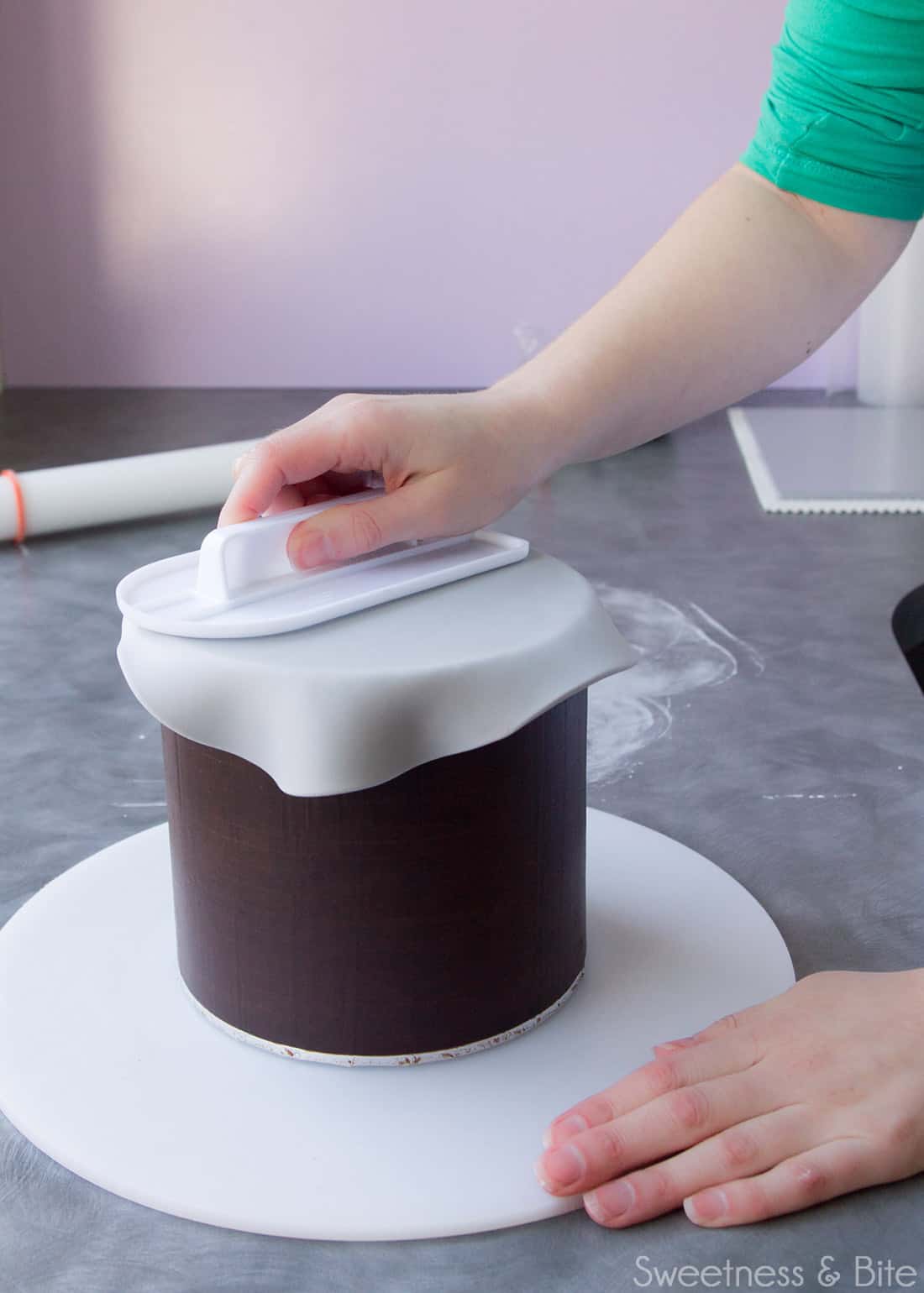 Using a fondant smoother to smooth out air bubbles under the fondant.