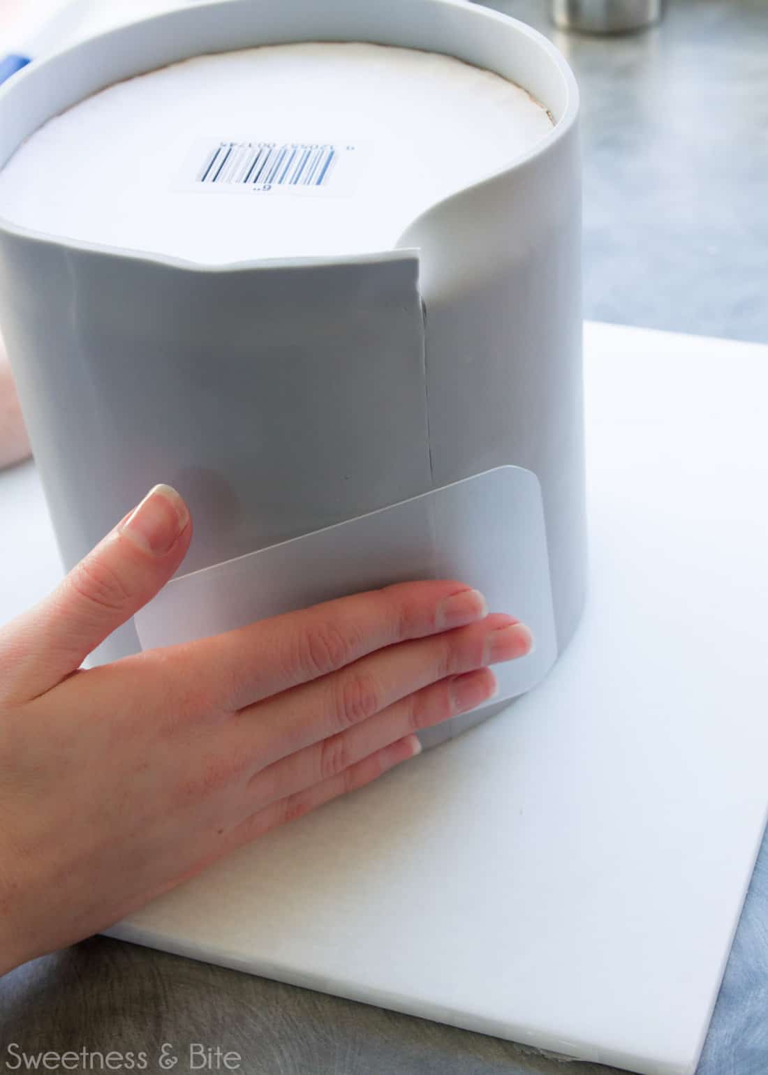 A flexible fondant smoother being used to buff the fondant join.