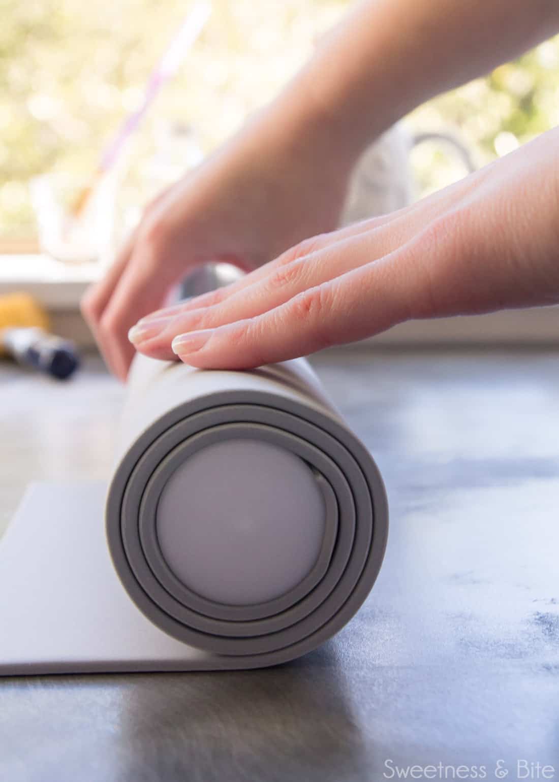 A close-up image of the fondant rolled around the rolling pin.