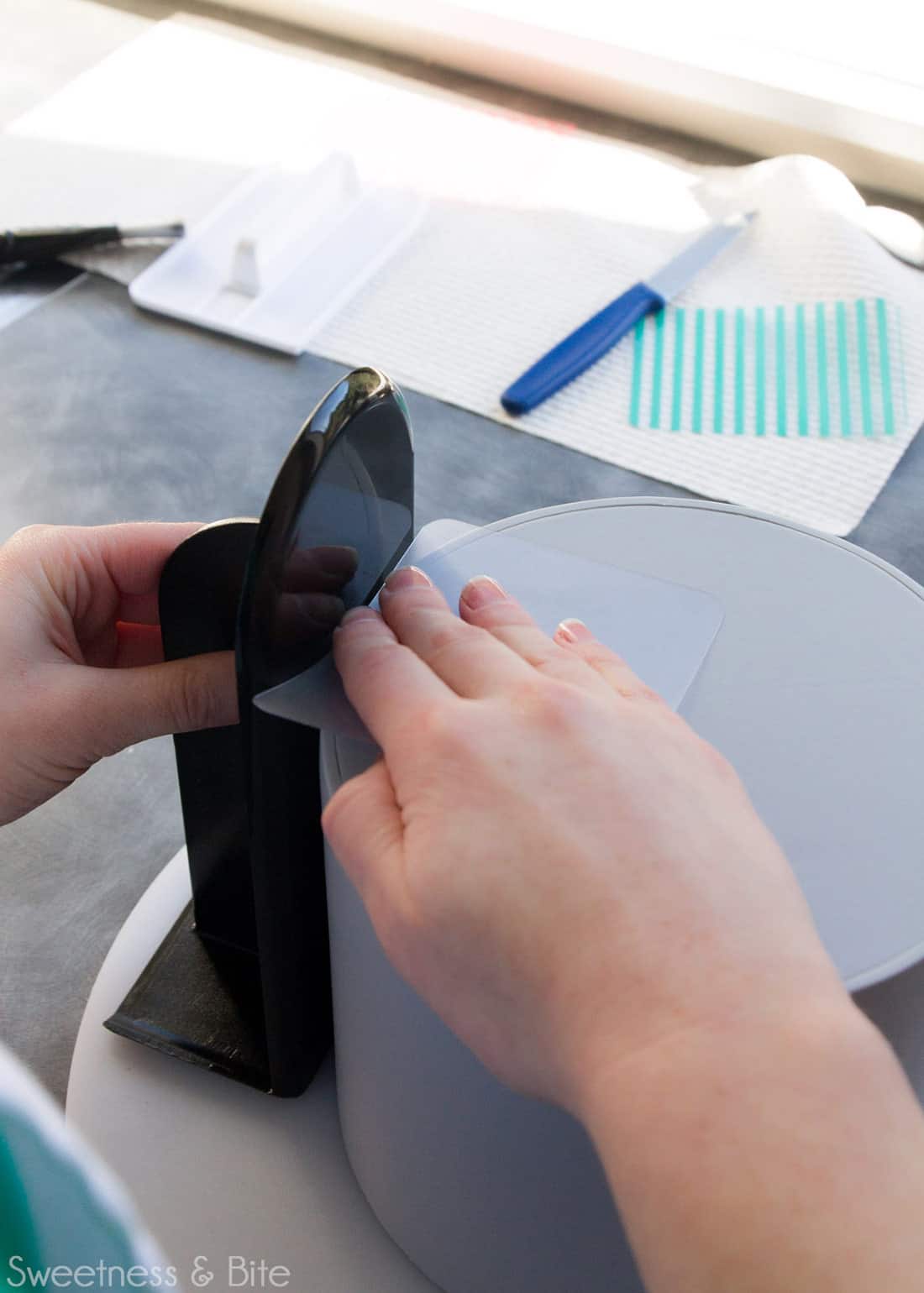 A close up showing the two fondant smoothers being used to press the seam together.