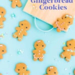 Gluten free gingerbread men and women cookies decorated with pastel royal icing, on a blue background.