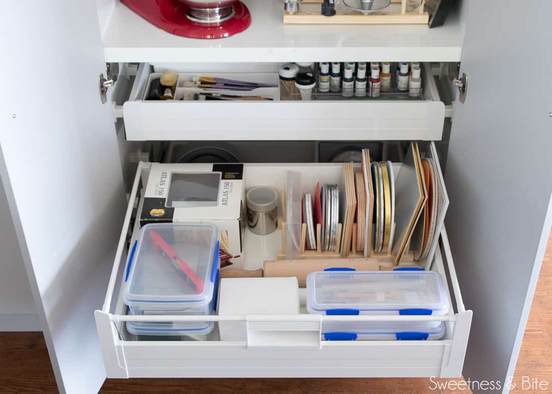 The middle of the lower drawers, with cake cards, a pasta machine and other tools.