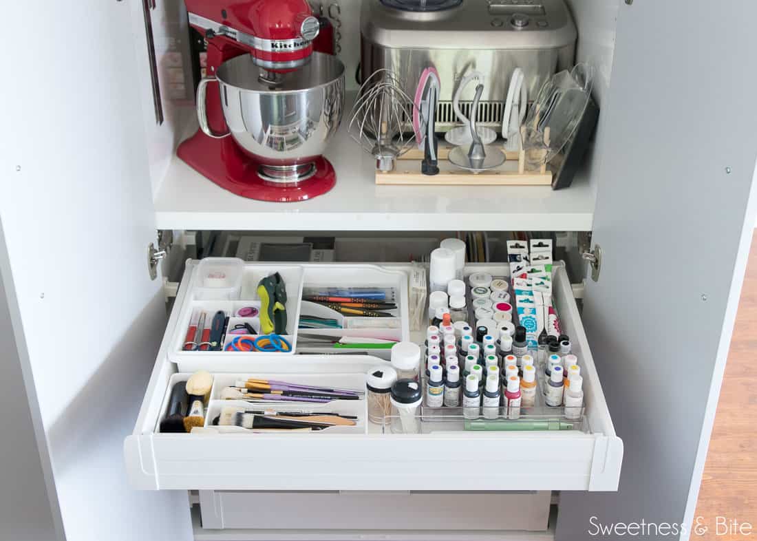 One of the large drawers in the lower part of the pantry, showing neatly organised food colouring bottles, paintbrushes and tools.