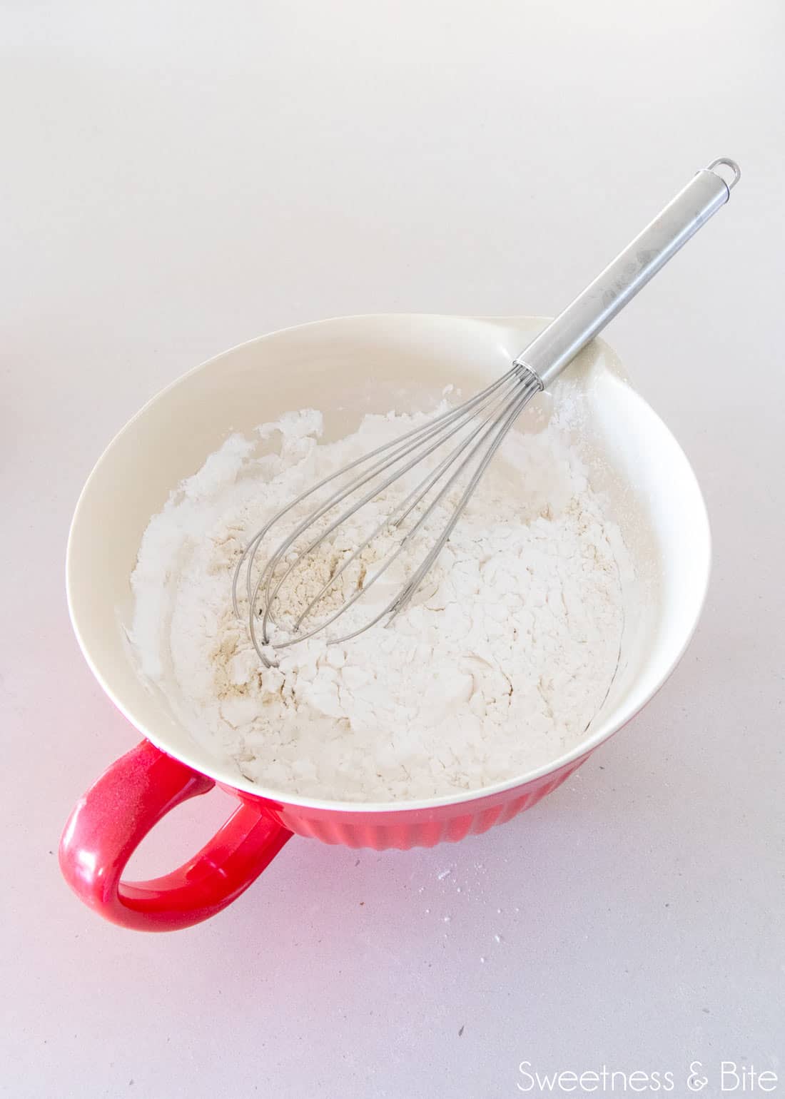 Flour being whisked together in a large bowl.