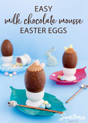 Mousse filled milk chocolate easter eggs in white egg cups on a blue background, with scattered pastel eggs.