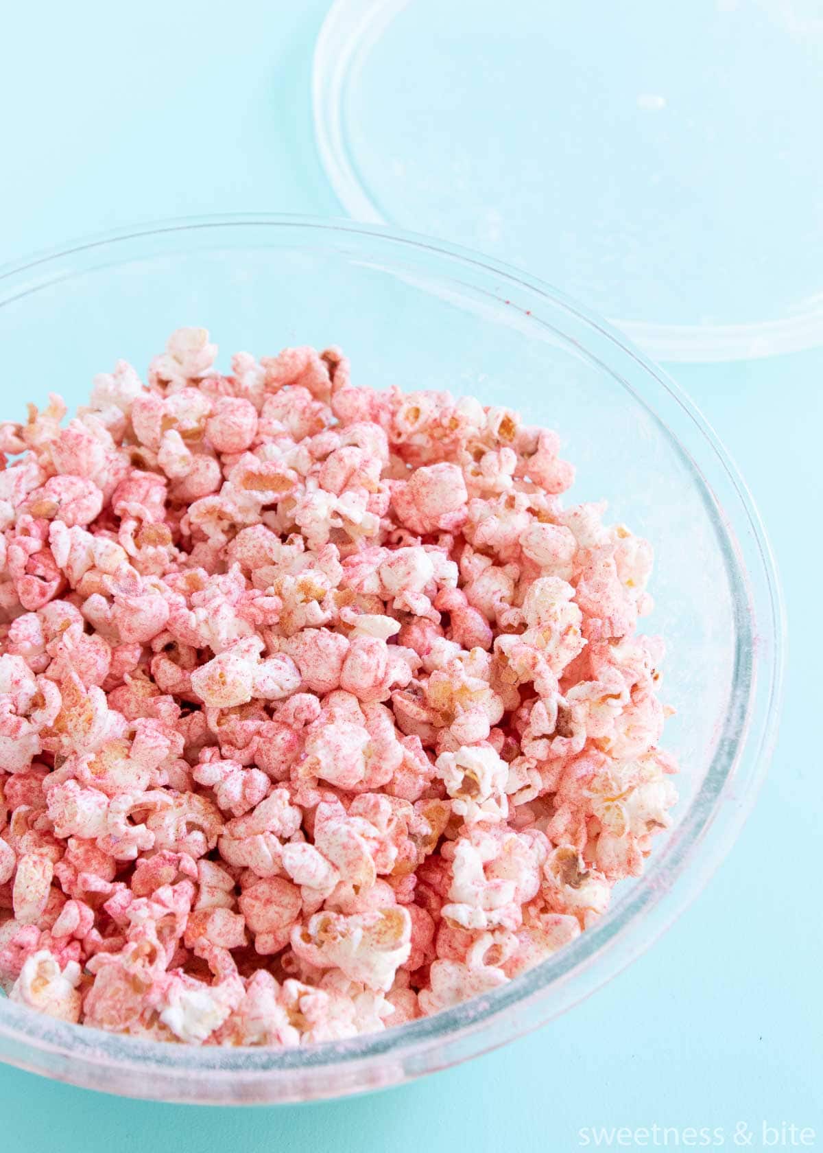 Glass bowl with the popcorn and fruit powder all mixed up.