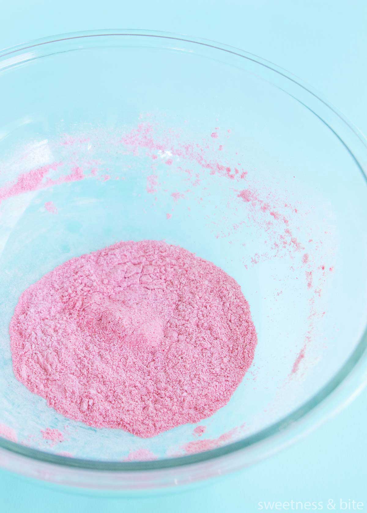 Freeze dried raspberry powder and icing sugar mixed together in a large bowl.