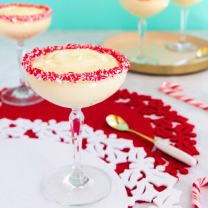 Easy peppermint mousse in a cocktail glass with crushed candy canes around the rim.