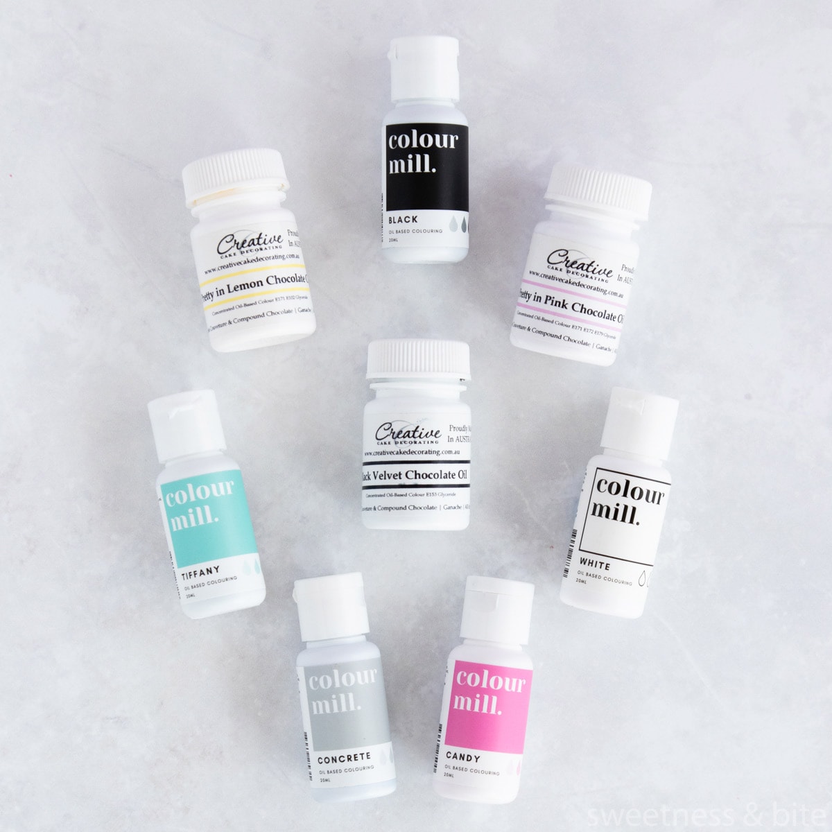 Bottles of Colour Mill and Creative Cake Decorating oil-based food colourings on a pale grey background.