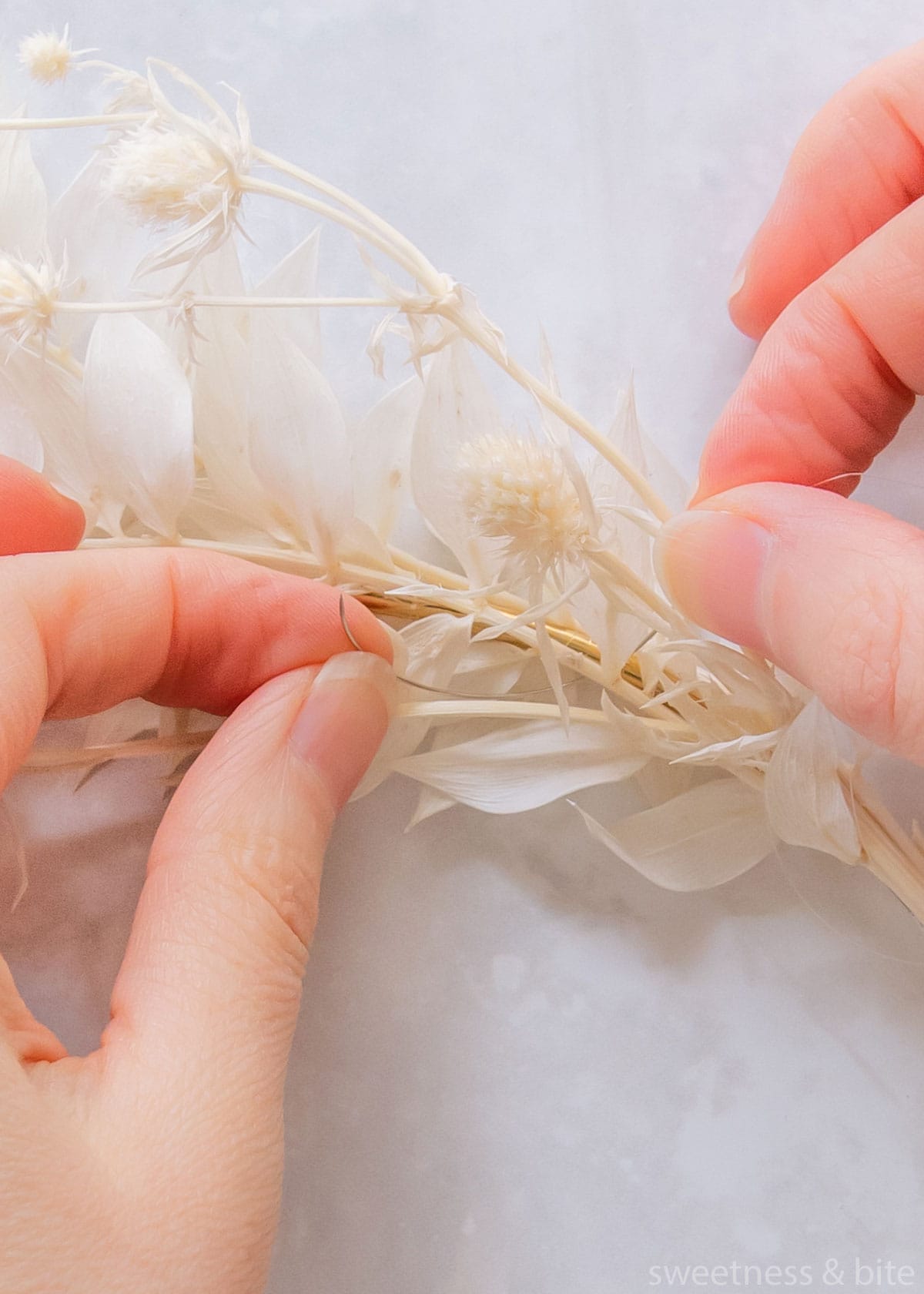 Using a curved beading needle to tie on a stem.