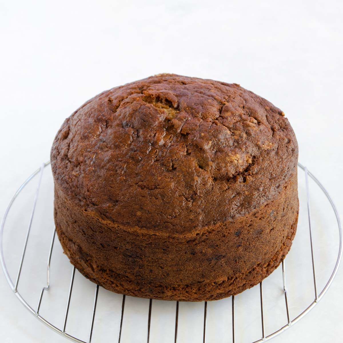 The baked banana cake on a round cooling rack.