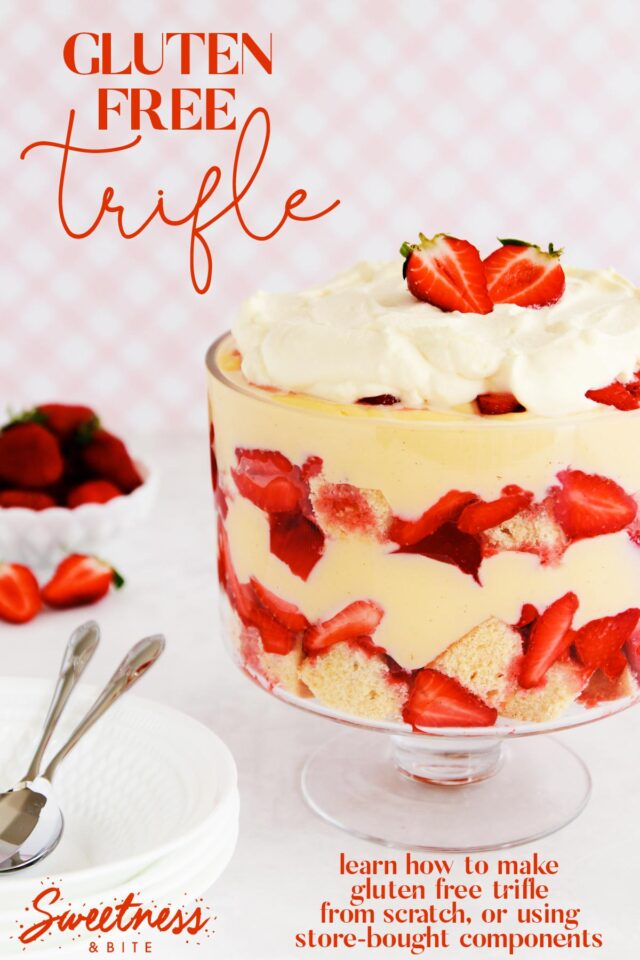 Gluten free trifle in a footed glass bowl on a pink background.