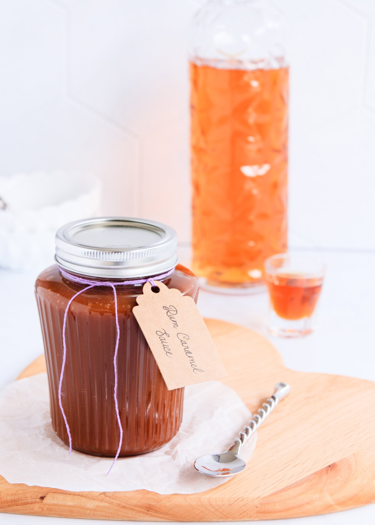 Rum caramel in a ribbed glass jar with a silver lid and a hand written label tied on with purple twine.