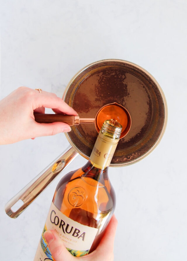 The rum being added to the caramel.