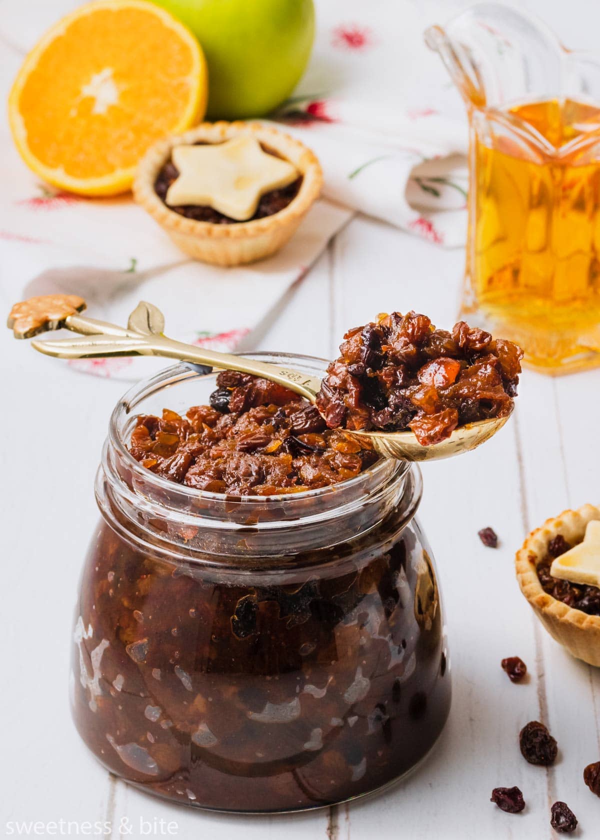 Close up of a spoonful of fruit mince resting on the top of an open jar.