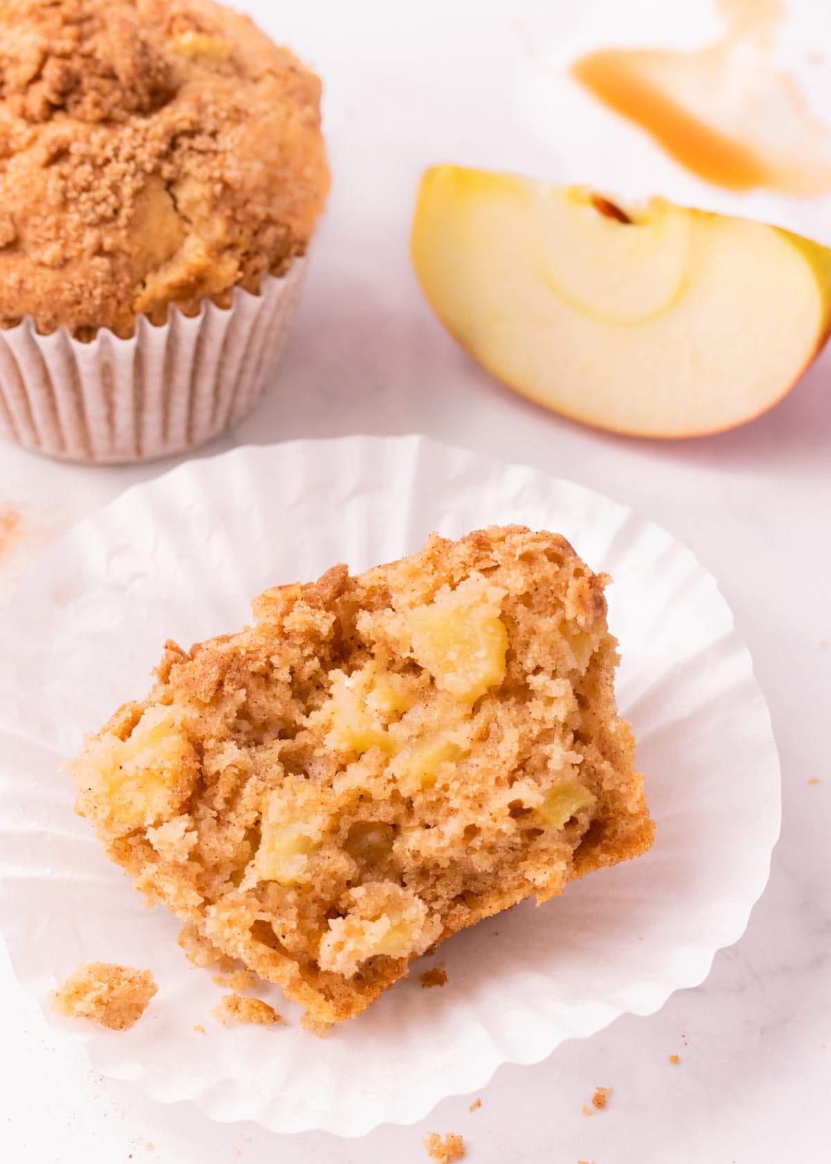 Half of a gf apple muffin, showing the texture of the muffin and the chunks of apple inside.