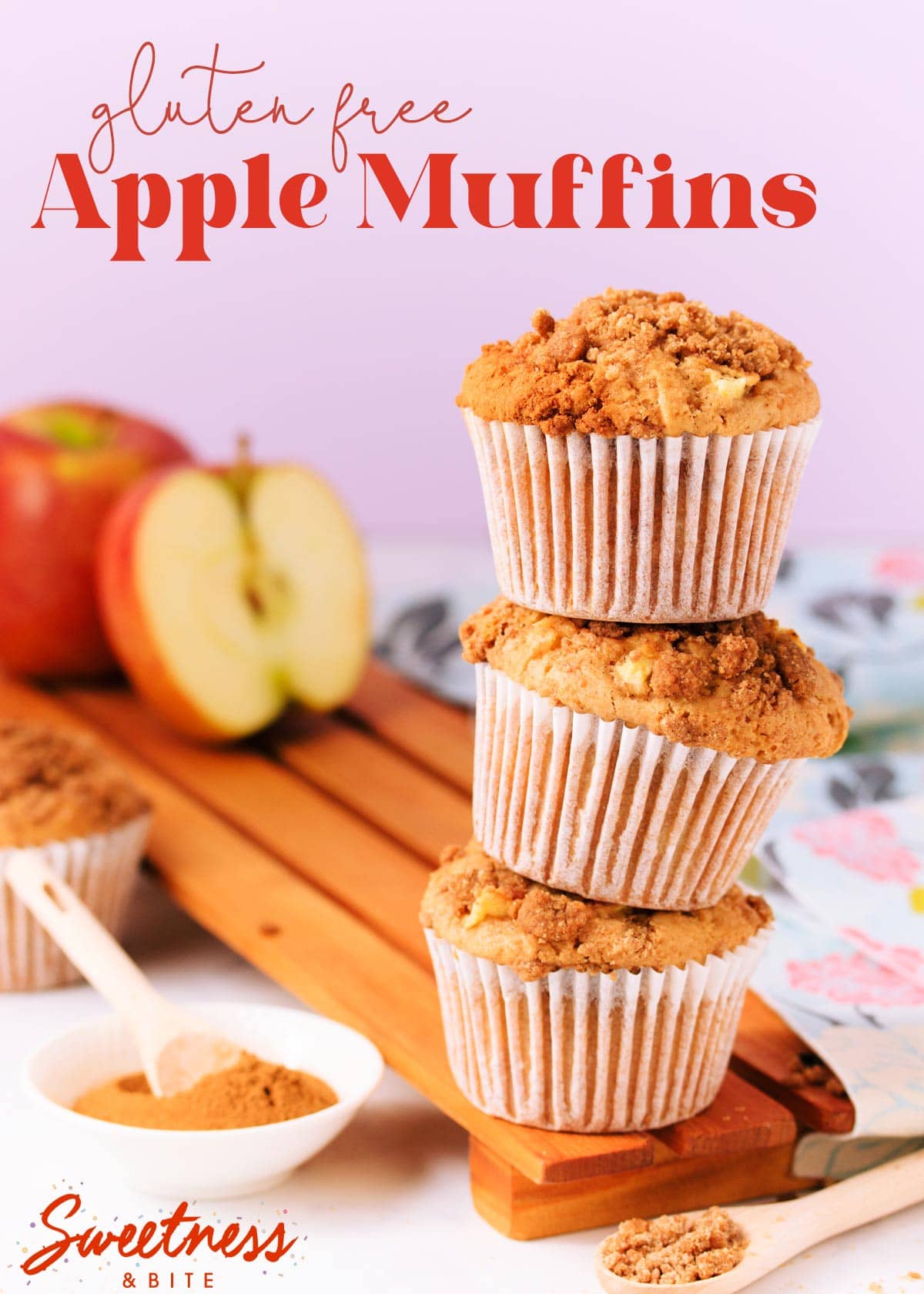 Three muffins stacked on top of each other, on a wooden board, with an apple and small dish of cinnamon in the background, text overlay reads 