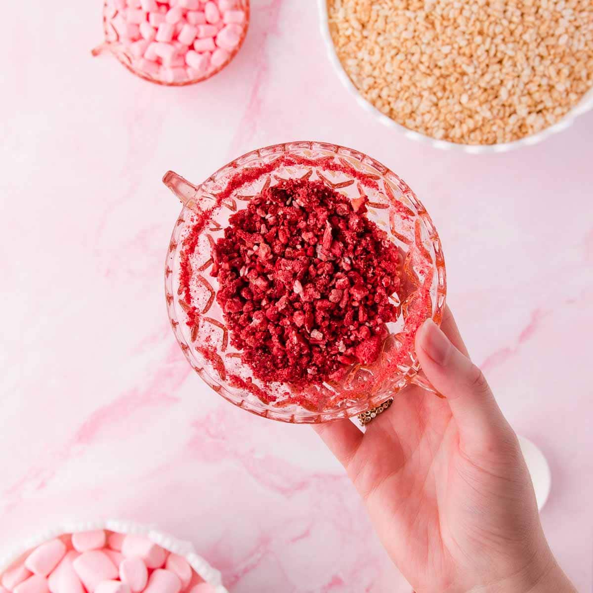 Crushed freeze-dried strawberries in a pink glass bowl.