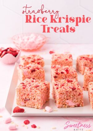 Six rice krispie treats on a white tray with scattered pieces of freeze-dried strawberry, text reads 