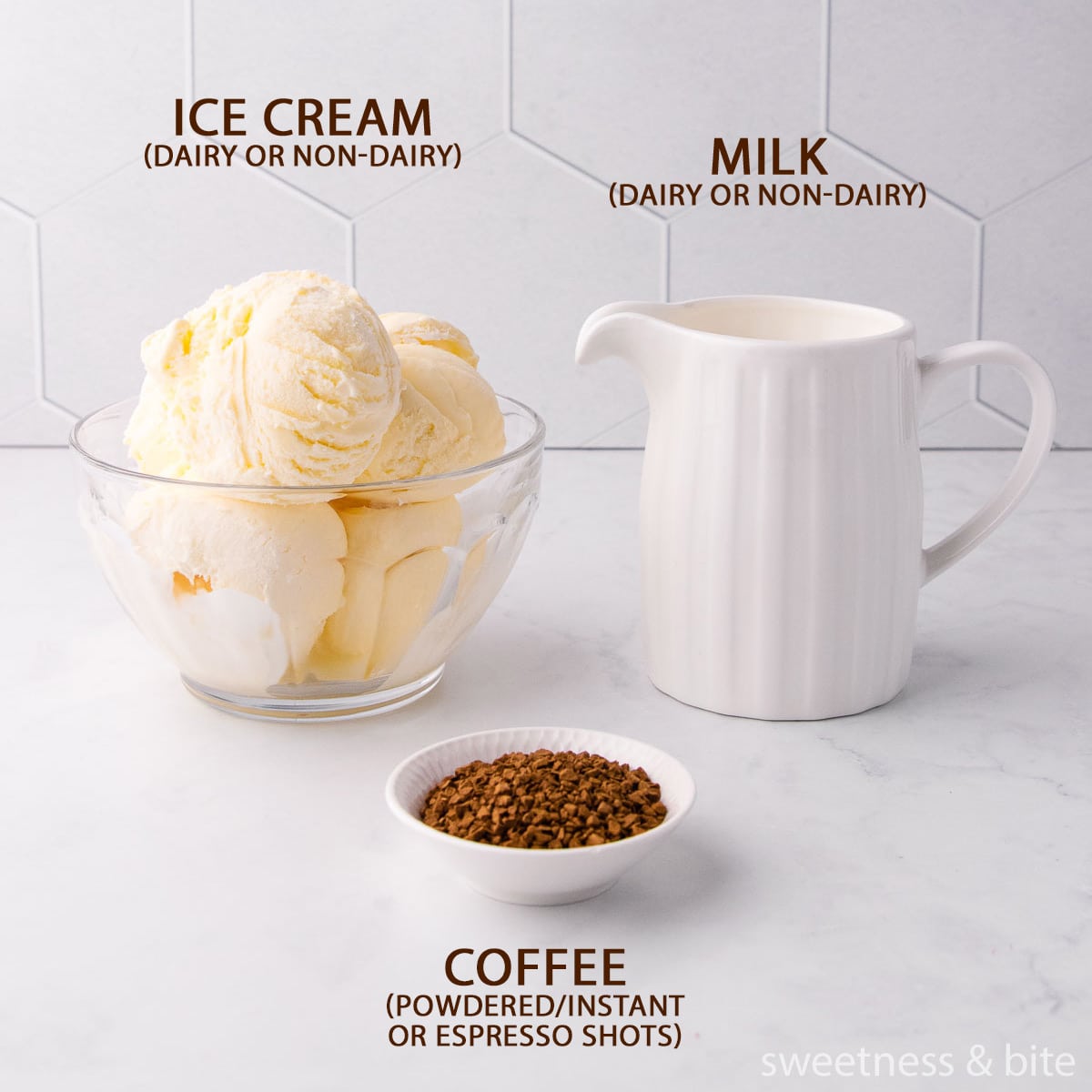 The coffee milkshake ingredients - scoops of vanilla ice cream in a glass bowl, milk in a white ceramic jug, and instant coffee granules in a small white bowl.