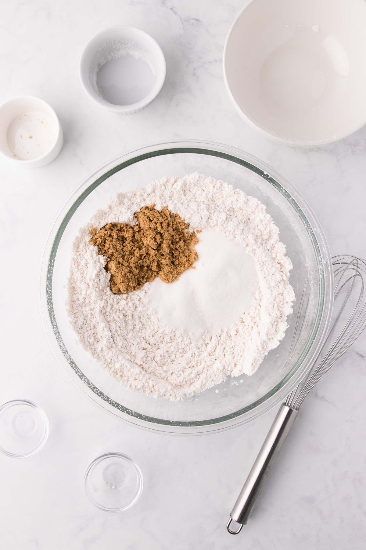 The sifted dry ingredients in a large glass bowl, with the white and brown sugar added. 