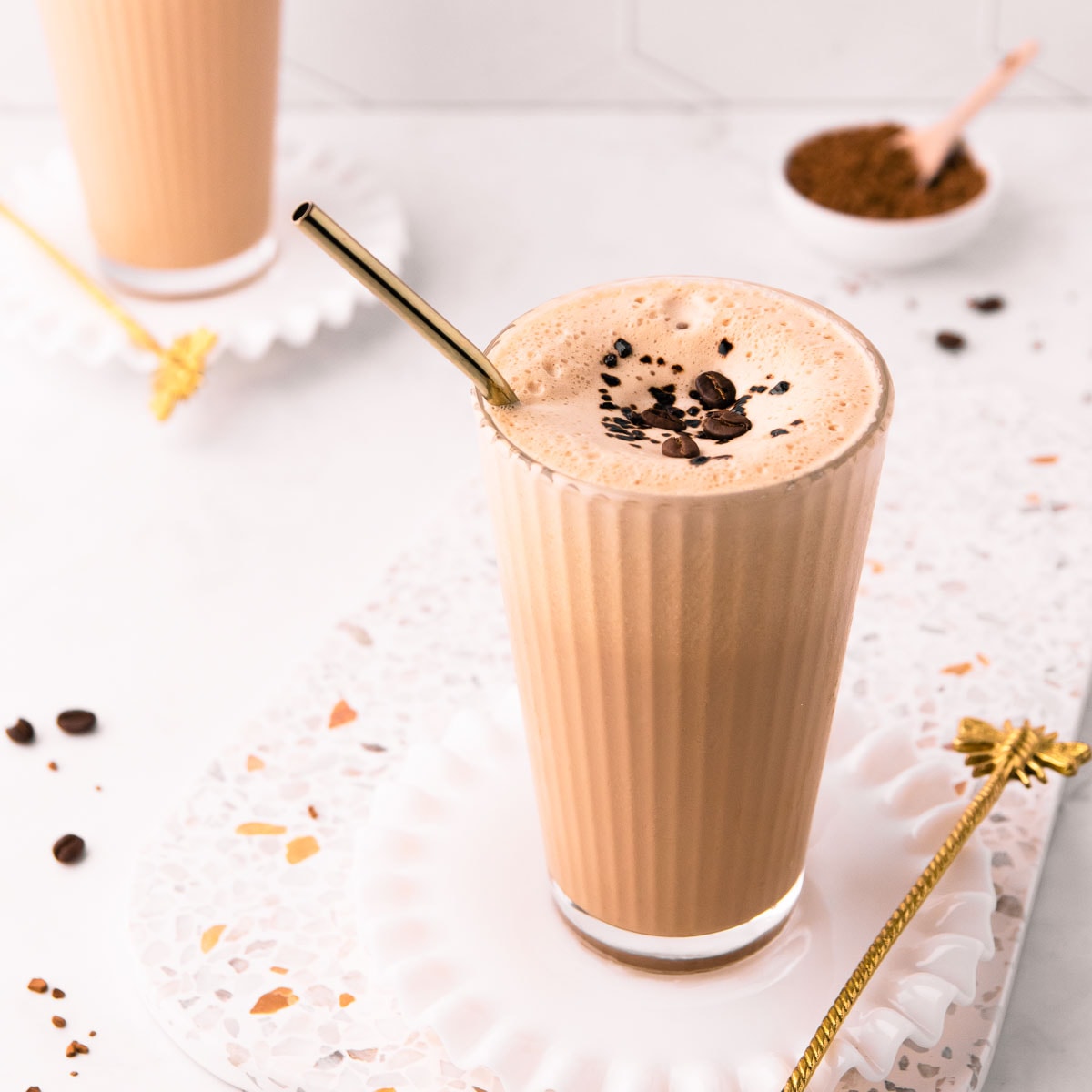 Splash of iced coffee in tall glass and coffee beans. Stock Photo