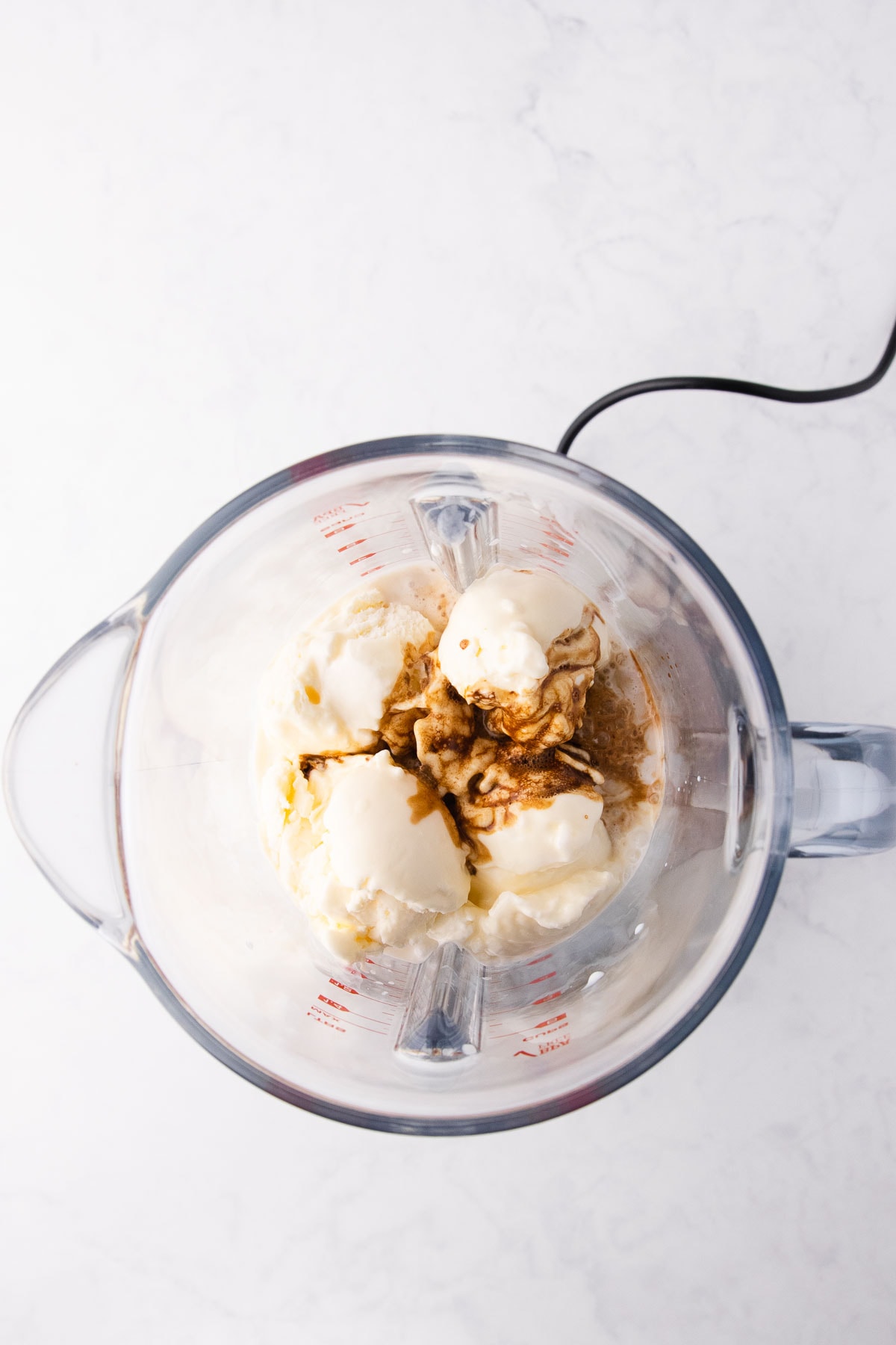 The scoops of ice cream, milk and coffee in a blender.