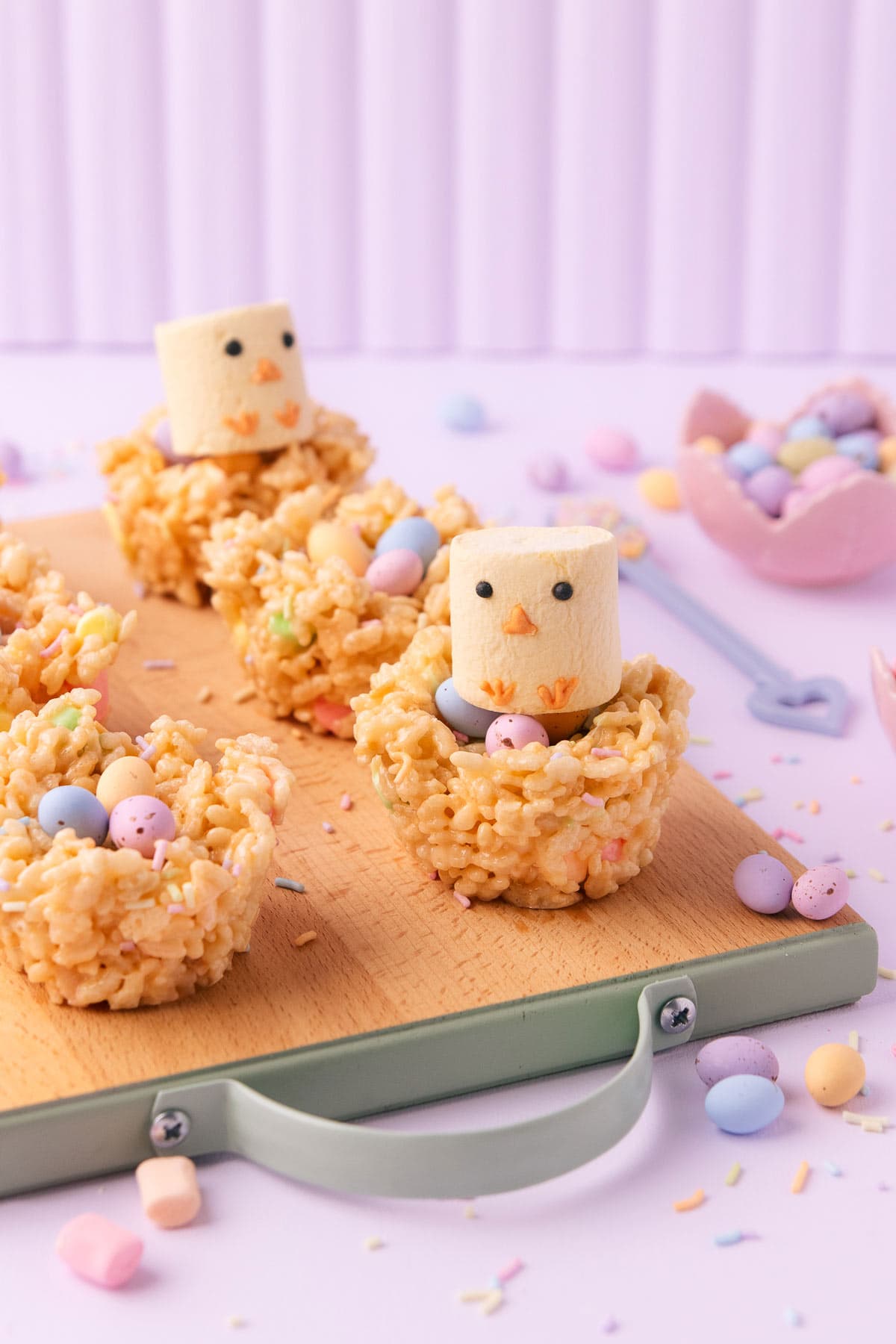 Little yellow marshmallows decorated to look like chickens, sitting on the rice krispie nests.
