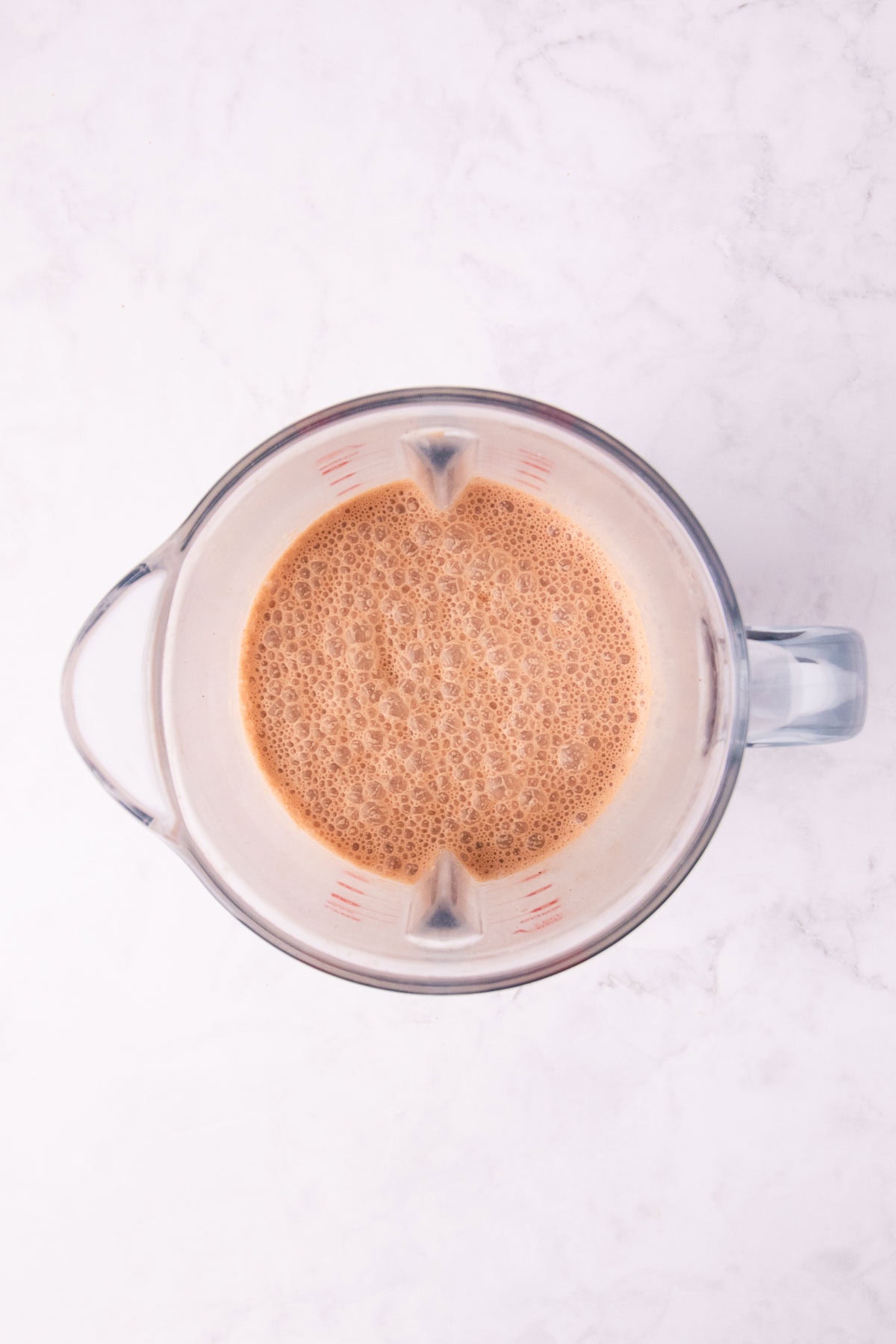 Overhead view of the blended shake in a clear blender jug.